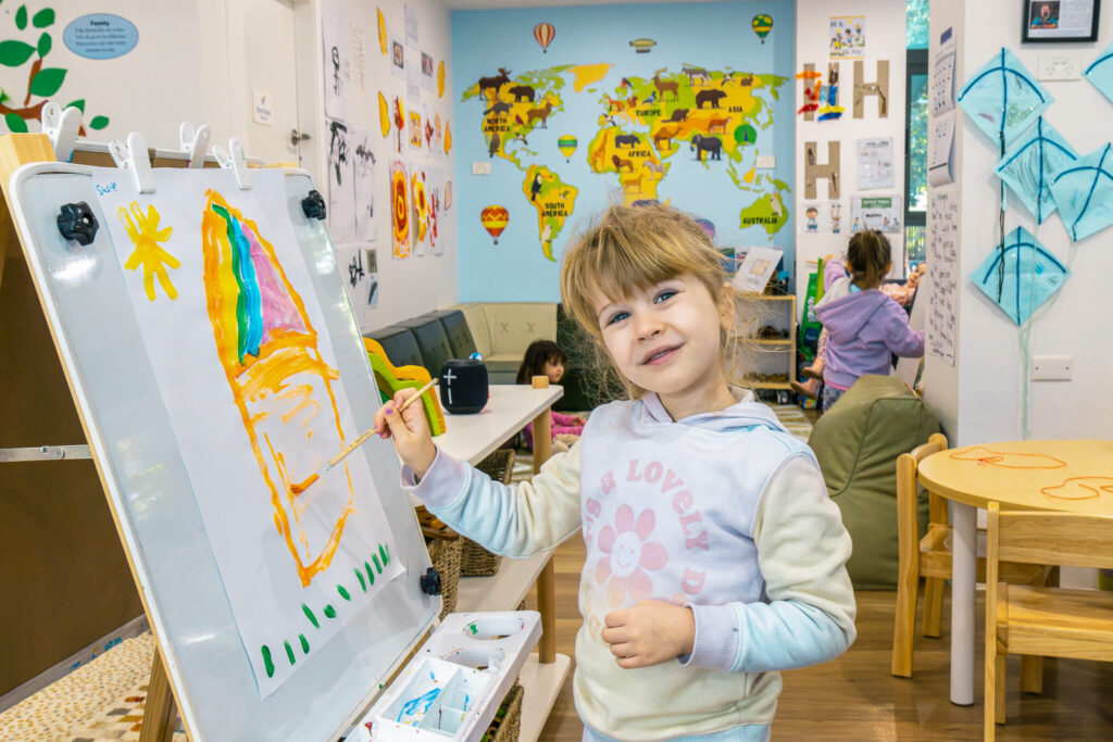 Preschool child engaged in painting at Little Gumnuts
