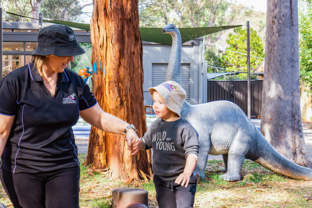 Child and educator playing outdoors at daycare center