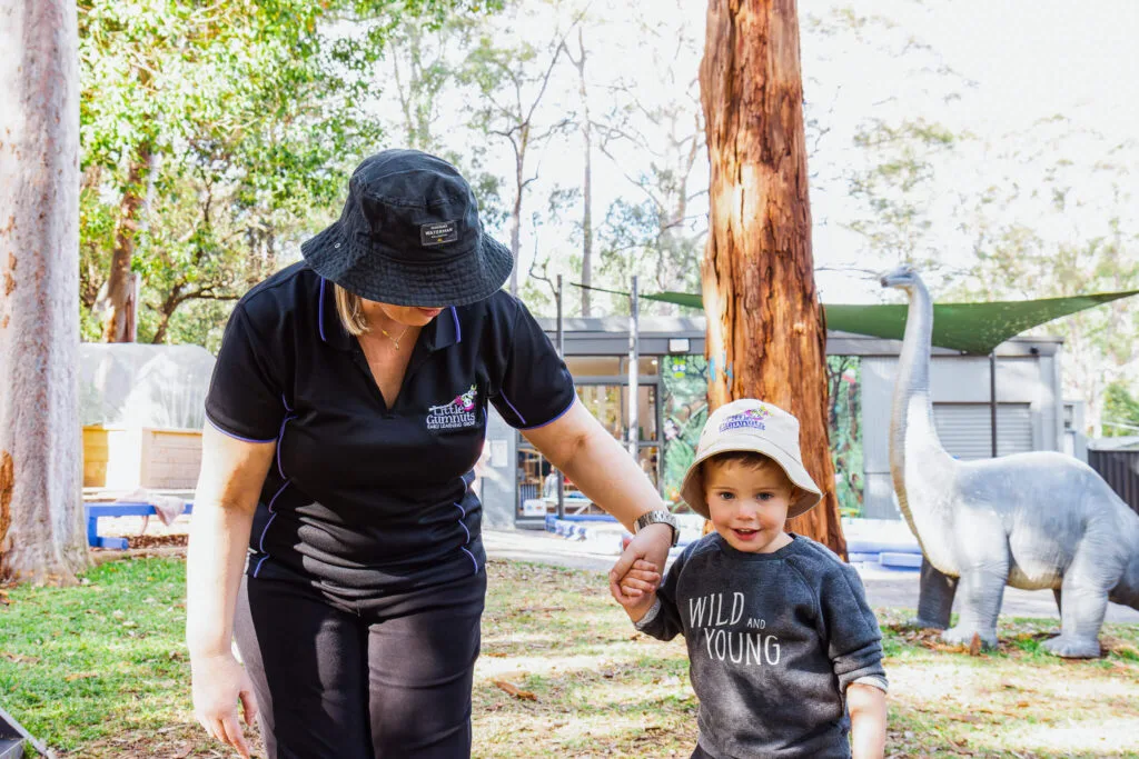 Child and educator playing outdoors at daycare center